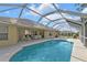 Screened pool surrounded by a spacious deck and serene waterfront views at 235 Tournament Rd, Rotonda West, FL 33947