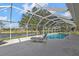 Inviting screened-in pool featuring a tranquil waterfront view and a relaxing lounge chair at 235 Tournament Rd, Rotonda West, FL 33947