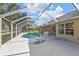 Relaxing screened-in pool area with comfortable lounge chair, patio table and chairs, perfect for outdoor entertainment at 235 Tournament Rd, Rotonda West, FL 33947