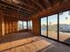 Framed living room with waterfront views through large windows and sliding doors during construction at 242 Bangsberg Se Rd, Port Charlotte, FL 33952