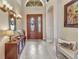 The foyer is enhanced by decorative tile floors and features a wood door with sidelights and transom at 24260 Westgate Blvd, Port Charlotte, FL 33980