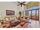 The living room has wood floors, high ceilings, a ceiling fan, and a sliding glass door to the lanai at 24260 Westgate Blvd, Port Charlotte, FL 33980