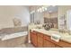 The main bathroom features double sinks, a tub, lovely tile work, and good lighting at 24260 Westgate Blvd, Port Charlotte, FL 33980