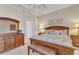 Well-lit main bedroom with wooden furnishings, carpet floors, trey ceiling and ceiling fan at 24260 Westgate Blvd, Port Charlotte, FL 33980