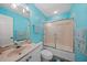 Bathroom featuring blue walls, a vanity, a shower-tub combo and themed towels at 25188 Marion Ave # 1033, Punta Gorda, FL 33950