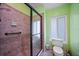 Bathroom featuring tile floors, a glass enclosed shower and green walls at 25188 Marion Ave # 1033, Punta Gorda, FL 33950