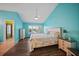Brightly painted primary bedroom boasts a ceiling fan, shuttered windows, and wood-look floors at 25188 Marion Ave # 1033, Punta Gorda, FL 33950