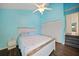 Bright bedroom with ceiling fan, light blue walls and white wood-style bed frame at 25188 Marion Ave # 1033, Punta Gorda, FL 33950