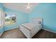 Bright bedroom with light blue walls, ceiling fan and shuttered window at 25188 Marion Ave # 1033, Punta Gorda, FL 33950