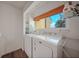 Convenient laundry room with window, washer, dryer, shelving, and view at 25188 Marion Ave # 1033, Punta Gorda, FL 33950