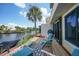 Relaxing outdoor patio with lounge chairs, lush landscaping, and a tranquil waterfront view at 25188 Marion Ave # 1033, Punta Gorda, FL 33950