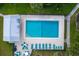 Aerial view of community pool with lounge chairs and tables with umbrellas overlooking the pool at 25188 Marion Ave # 1033, Punta Gorda, FL 33950