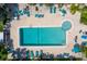 Aerial view of community pool and hot tub with lounge chairs and tables with umbrellas around the pool at 25188 Marion Ave # 1033, Punta Gorda, FL 33950