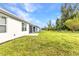 Large backyard with grass, trees, and patio with screened in enclosure at 25340 E Lenox Cir, Punta Gorda, FL 33950