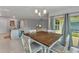Open concept dining room features backyard views, chandelier, and sliding glass doors at 25340 E Lenox Cir, Punta Gorda, FL 33950