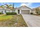 Charming single-story home featuring well-kept landscaping, palm tree, and a two-car garage at 25340 E Lenox Cir, Punta Gorda, FL 33950