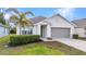 Charming single-story home featuring well-kept landscaping, palm tree, and a two-car garage at 25340 E Lenox Cir, Punta Gorda, FL 33950