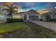Charming single-story home featuring well-kept landscaping, palm tree, and a two-car garage at 25340 E Lenox Cir, Punta Gorda, FL 33950