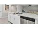 Kitchen island with stainless steel dishwasher, white cabinets, and hard surface countertops at 25340 E Lenox Cir, Punta Gorda, FL 33950
