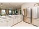 Modern kitchen with stainless steel appliances, white cabinets, and a spacious island counter, open to living area at 25340 E Lenox Cir, Punta Gorda, FL 33950
