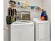 Functional laundry room featuring a white washer and dryer, with shelving for storage solutions at 25340 E Lenox Cir, Punta Gorda, FL 33950