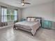 Cozy main bedroom featuring tile flooring, a ceiling fan, and natural light at 25340 E Lenox Cir, Punta Gorda, FL 33950