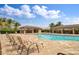 Community pool area featuring lounge chairs, covered seating, and lush landscaping, ideal for relaxation at 25340 E Lenox Cir, Punta Gorda, FL 33950