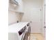 Laundry room with white washer and dryer, upper cabinets and wire shelving at 2607 Valerian Way, North Port, FL 34289
