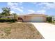 Charming one-story home featuring a white garage door, a tile roof, and lush landscaping at 2621 Via Veneto Dr, Punta Gorda, FL 33950