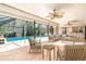 Staged view of the screened-in porch with furniture around the pool, featuring ceiling fans at 2621 Via Veneto Dr, Punta Gorda, FL 33950