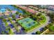 Overhead view of tennis courts, a parking lot, and landscaping near a serene pond in a lovely neighborhood at 264 Soliera St, Nokomis, FL 34275