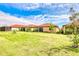 Spacious backyard featuring a lush green lawn with lovely landscaping and vibrant blue skies at 264 Soliera St, Nokomis, FL 34275
