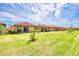Expansive green lawn in a serene backyard setting, lined with lovely landscaping and a clear blue sky at 264 Soliera St, Nokomis, FL 34275
