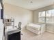 Neutral bedroom featuring a twin daybed with drawers, a study desk with chair, and a window with blinds at 264 Soliera St, Nokomis, FL 34275