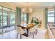 Elegant dining room with modern chandelier, neutral decor, and sliding glass doors to a screened patio at 264 Soliera St, Nokomis, FL 34275