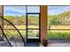 Cozy screened-in patio with a view of the backyard and a black hanging swing chair at 264 Soliera St, Nokomis, FL 34275