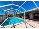 Relaxing screened-in pool area with brick pavers, lounge chairs, and serene waterfront views at 275 Tait Se Ter, Port Charlotte, FL 33952