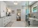 Contemporary bathroom featuring double vanities, a soaking tub, and a walk-in glass shower at 310 Severin Se Rd, Port Charlotte, FL 33952