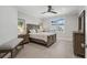 Relaxing bedroom with a wood-frame bed, dresser, soft lighting, and a view of the pool area at 310 Severin Se Rd, Port Charlotte, FL 33952