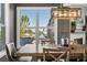 Well-lit dining room with a wooden table, chandelier, and waterfront views through a large window at 310 Severin Se Rd, Port Charlotte, FL 33952