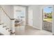 Inviting foyer with tiled floors, staircase, and a glimpse into the sunlit living room at 310 Severin Se Rd, Port Charlotte, FL 33952