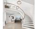 Bright foyer with curved staircase, chandelier, and neutral decor offers an inviting entrance to the home at 310 Severin Se Rd, Port Charlotte, FL 33952