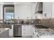 Kitchen with white cabinets, gray backsplash, granite countertops, stainless steel appliances, and water view at 310 Severin Se Rd, Port Charlotte, FL 33952