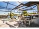 Enclosed lanai featuring a dining set and a hot tub overlooking the canal, ideal for outdoor entertainment at 310 Severin Se Rd, Port Charlotte, FL 33952