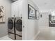 Modern laundry room featuring a washer and dryer, storage cabinets, and artwork at 310 Severin Se Rd, Port Charlotte, FL 33952
