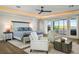 Bright main bedroom with hardwood floors, tray ceiling, balcony access, and views of the water at 310 Severin Se Rd, Port Charlotte, FL 33952