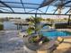 Screened-in pool with lush greenery and view of the canal and boat dock at 310 Severin Se Rd, Port Charlotte, FL 33952