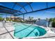 Sparkling screened-in pool with waterfront view, sun loungers, and a nearby boat dock at 310 Severin Se Rd, Port Charlotte, FL 33952