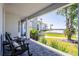 Relaxing outdoor porch with comfortable rocking chairs overlooking a beautiful waterfront view and lush landscaping at 310 Severin Se Rd, Port Charlotte, FL 33952