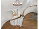 Elegant staircase with wooden steps, white railings, and a modern chandelier at 310 Severin Se Rd, Port Charlotte, FL 33952